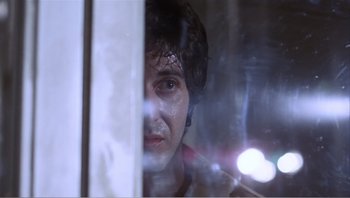 Movie still from “Dog Day Afternoon” (1975), directed by Sidney Lumet – A young man looking out of a window at night; Close Up shot, Low angle
