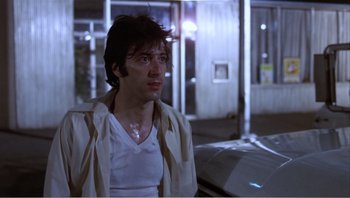 Movie still from “Dog Day Afternoon” (1975), directed by Sidney Lumet – A man in a white shirt and a white jacket; Medium shot, Low angle