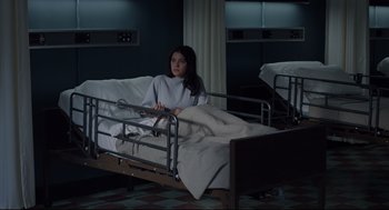Movie still from “The New Mutants” (2020), directed by Josh Boone – A woman sitting on a hospital bed in a hospital room; Wide shot, High angle