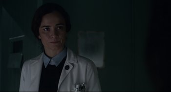 Movie still from “The New Mutants” (2020), directed by Josh Boone – A woman in a white lab coat is standing in a room; Close Up shot, Over the shoulder angle