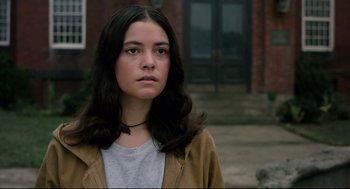 Movie still from “The New Mutants” (2020), directed by Josh Boone – A woman with long black hair standing in front of a building; Close Up shot, Low angle