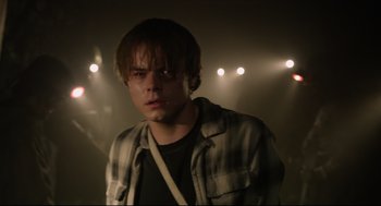 Movie still from “The New Mutants” (2020), directed by Josh Boone – A young man in a plaid shirt is in the spotlight; Close Up shot, Over the shoulder angle
