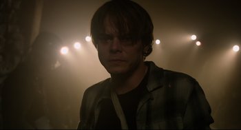 Movie still from “The New Mutants” (2020), directed by Josh Boone – A man in a dark room with lights in the background; Close Up shot, Over the shoulder angle