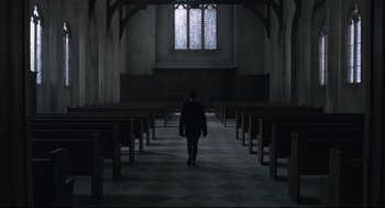 Movie still from “The New Mutants” (2020), directed by Josh Boone – A person walking through a church with pews in front of them; Extreme Wide shot, Low angle