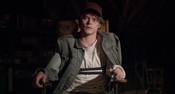 Movie still from “The New Mutants” (2020), directed by Josh Boone – A man sitting in a chair holding a game controller; Medium shot, High angle