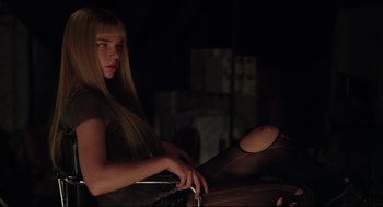 Movie still from “The New Mutants” (2020), directed by Josh Boone – A woman sitting in a chair in a dark room; Medium shot, Low angle