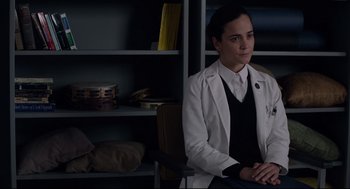 Movie still from “The New Mutants” (2020), directed by Josh Boone – A woman in a white lab coat sitting in front of a book shelf; Medium shot, Over the shoulder angle