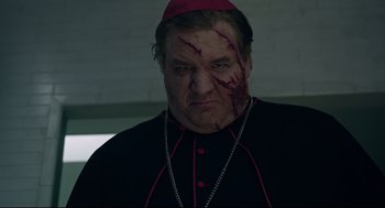 Movie still from “The New Mutants” (2020), directed by Josh Boone – A man in a priest's outfit with blood all over his face; Close Up shot, Low angle