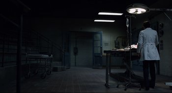 Movie still from “The New Mutants” (2020), directed by Josh Boone – A dark room with a table and a chair; Wide shot, High angle