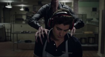 Movie still from “The New Mutants” (2020), directed by Josh Boone – A man wearing headphones and a black shirt; Medium shot, Over the shoulder angle