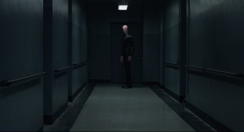 Movie still from “The New Mutants” (2020), directed by Josh Boone – A man standing in a dark hallway looking at the camera; Wide shot, Low angle
