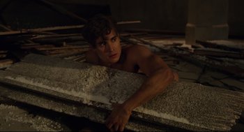 Movie still from “The New Mutants” (2020), directed by Josh Boone – A man laying on the ground looking at the camera; Medium shot, High angle