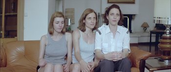 Movie still from “Dogtooth” (2009), directed by Yorgos Lanthimos – A group of three women sitting on a couch together; Medium shot, Low angle