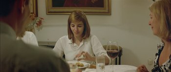 Movie still from “Dogtooth” (2009), directed by Yorgos Lanthimos – A woman sitting at a table with a plate of food; Medium shot, Over the shoulder angle