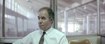 Movie still from “Dogtooth” (2009), directed by Yorgos Lanthimos – A man in a white dress shirt and a brown tie; Close Up shot, Low angle