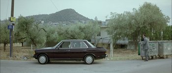 Movie still from “Dogtooth” (2009), directed by Yorgos Lanthimos – An old car is parked on the side of the road; Wide shot, Low angle
