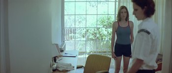 Movie still from “Dogtooth” (2009), directed by Yorgos Lanthimos – A woman standing in front of an open window; Medium shot, Low angle