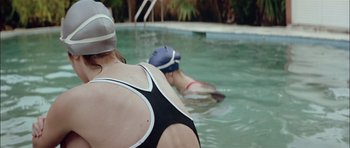 Movie still from “Dogtooth” (2009), directed by Yorgos Lanthimos – Two people in a swimming pool with helmets on; Medium shot, Over the shoulder angle