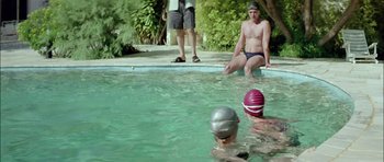 Movie still from “Dogtooth” (2009), directed by Yorgos Lanthimos – A group of people swimming in a swimming pool; Wide shot, Over the shoulder angle