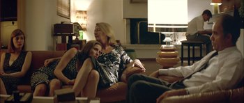 Movie still from “Dogtooth” (2009), directed by Yorgos Lanthimos – A woman and a girl sitting on a couch; Medium shot, Over the shoulder angle