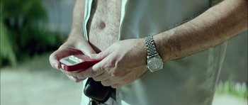 Movie still from “Dogtooth” (2009), directed by Yorgos Lanthimos – A person holding a cell phone; Extreme Close Up shot, Low angle