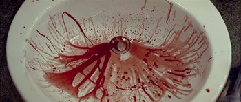 Movie still from “Dogtooth” (2009), directed by Yorgos Lanthimos – View of a ring with blood coming out of it; Extreme Close Up shot, Overhead angle