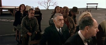 Movie still from “Dogville” (2003), directed by Lars von Trier – A group of people sitting in a room; Medium shot, High angle