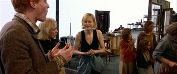 Movie still from “Dogville” (2003), directed by Lars von Trier – A woman in a black top is talking to two other people; Medium shot, Over the shoulder angle