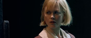 Movie still from “Dogville” (2003), directed by Lars von Trier – A woman with short blonde hair is looking at the camera; Close Up shot, Over the shoulder angle