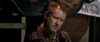 Movie still from “Dogville” (2003), directed by Lars von Trier – A person wearing a brown jacket; Close Up shot, High angle