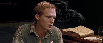 Movie still from “Dogville” (2003), directed by Lars von Trier – A man in a plaid shirt is talking to someone; Close Up shot, High angle