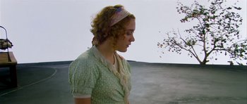 Movie still from “Dogville” (2003), directed by Lars von Trier – A woman with curly red hair wearing a head scarf; Medium shot, High angle