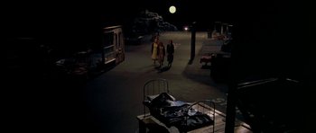 Movie still from “Dogville” (2003), directed by Lars von Trier – Three people walking on a street at night; Extreme Wide shot, High angle