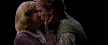 Movie still from “Dogville” (2003), directed by Lars von Trier – A man and a woman kissing on a stage; Close Up shot, Low angle