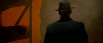 Movie still from “Dogville” (2003), directed by Lars von Trier – A man wearing a hat and a black coat; Close Up shot, Over the shoulder angle