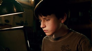 Movie still from “Dolphin Tale” (2011), directed by Charles Martin Smith – A young boy is looking down at a lamp; Close Up shot, Low angle