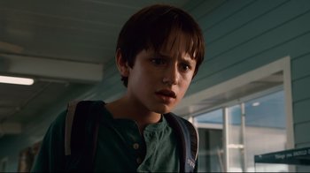 Movie still from “Dolphin Tale” (2011), directed by Charles Martin Smith – A young boy with a green shirt and brown backpack; Close Up shot, Low angle