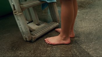 Movie still from “Dolphin Tale” (2011), directed by Charles Martin Smith – A person standing next to a chair with their bare feet; Extreme Close Up shot, High angle