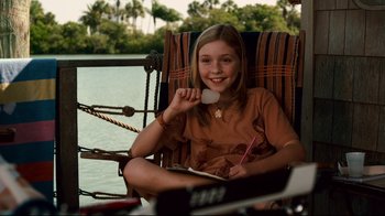 Movie still from “Dolphin Tale” (2011), directed by Charles Martin Smith – A young girl sitting in a chair holding a pen and paper; Medium shot, High angle