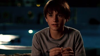 Movie still from “Dolphin Tale” (2011), directed by Charles Martin Smith – A young boy sitting in front of a window at night; Close Up shot, Over the shoulder angle