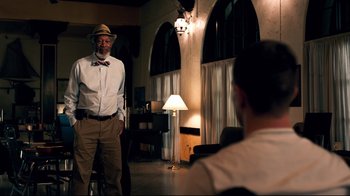 Movie still from “Dolphin Tale” (2011), directed by Charles Martin Smith – An older man wearing a hat and a bow tie standing in a room; Medium shot, Over the shoulder angle