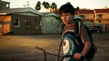 Movie still from “Dolphin Tale” (2011), directed by Charles Martin Smith – A young boy with a backpack on a bike; Medium shot, Low angle