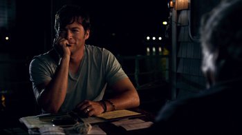 Movie still from “Dolphin Tale” (2011), directed by Charles Martin Smith – A man sitting at a dinner table at night; Medium shot, Over the shoulder angle