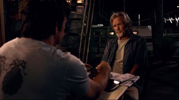 Movie still from “Dolphin Tale” (2011), directed by Charles Martin Smith – A man sitting next to another man holding a cell phone; Medium shot, Over the shoulder angle