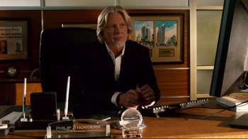 Movie still from “Dolphin Tale” (2011), directed by Charles Martin Smith – A man sitting at a desk in front of a painting; Medium shot, Over the shoulder angle