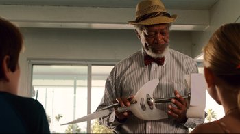 Movie still from “Dolphin Tale” (2011), directed by Charles Martin Smith – An older man wearing a hat and holding a guitar; Medium shot, Low angle