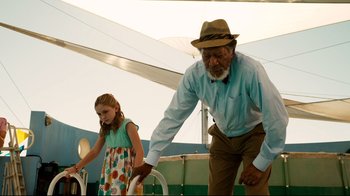 Movie still from “Dolphin Tale” (2011), directed by Charles Martin Smith – An older man and a young girl are playing a game; Medium shot, Low angle
