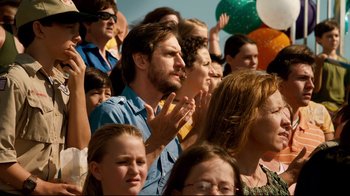 Movie still from “Dolphin Tale” (2011), directed by Charles Martin Smith – A group of people standing in a crowd clapping; Medium shot, Over the shoulder angle