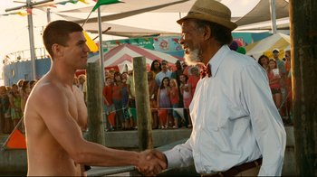 Movie still from “Dolphin Tale” (2011), directed by Charles Martin Smith – Two men shaking hands in front of a crowd; Medium shot, Over the shoulder angle