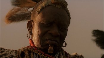 Movie still from “Dominion: Prequel to the Exorcist” (2005), directed by Paul Schrader – An old man with a long beard and a long necklace; Close Up shot, Low angle